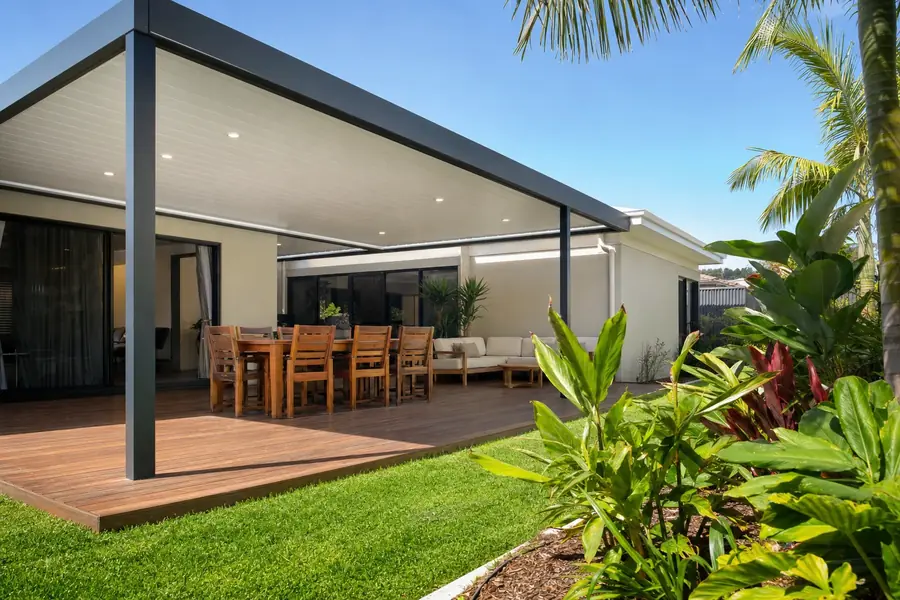 Flat roof patio with a white panel ceiling and downlights over a timber deck and dining table