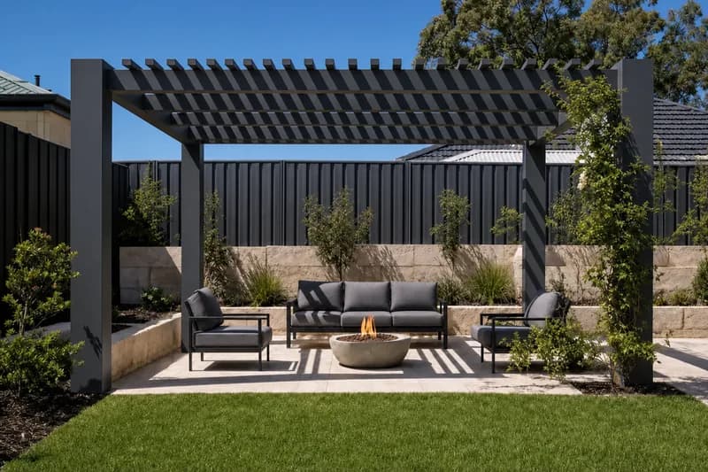Freestanding pergola with an open slatted roof over a backyard lounge